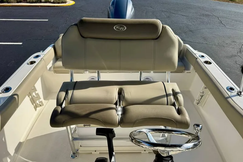 Slide: The Image of 2023 Key West 219 FS boat interior with cushioned seating and steering wheel. - 15