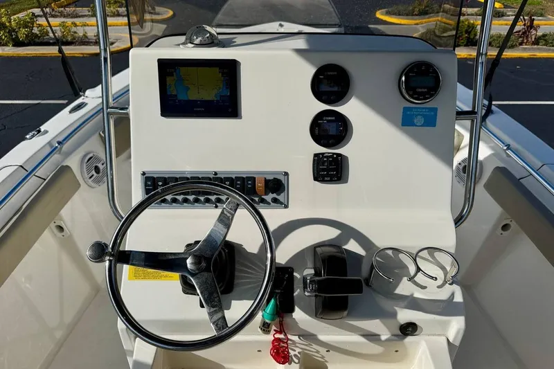 Slide: The Image of 2023 Key West 219 FS boat dashboard with steering wheel and navigation controls. - 18