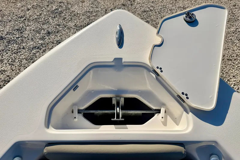 Slide: The Image of 2023 Key West 219 FS boat anchor compartment with open hatch on gravel surface. - 30
