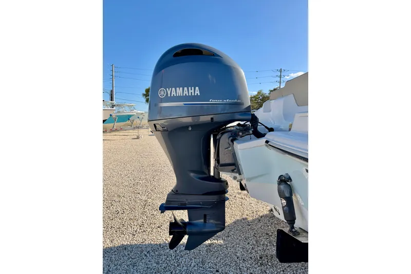Slide: The Image of 2023 Key West 219 FS boat with Yamaha outboard motor in a sunny outdoor setting. - 32