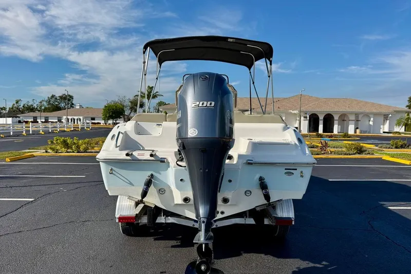 Slide: The Image of 2023 Key West 219 FS boat with 200 HP engine in parking lot. - 5
