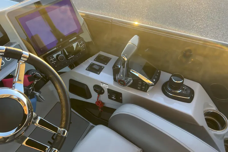 Slide: The Image of Control panel of 2025 Paradigm 27SST boat with steering wheel and navigation controls. - 12