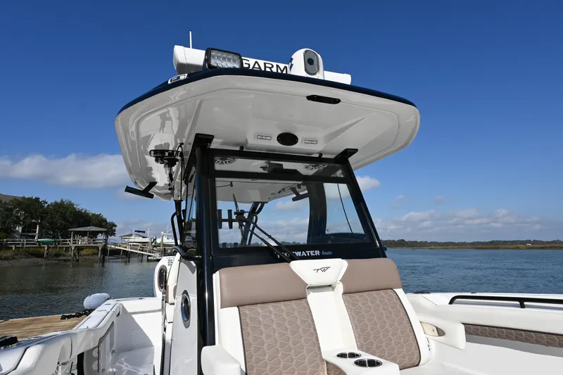 Slide: The Image of 2025 Tidewater 320 CC Adventure boat with advanced navigation equipment on a sunny day. - 11