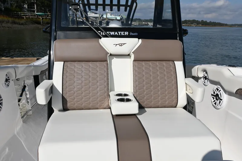 Slide: The Image of 2025 Tidewater 320 CC Adventure boat seating with cup holders, featuring elegant brown and white upholstery. - 12