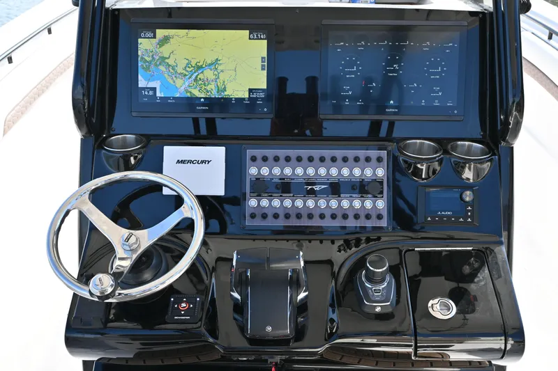 Slide: The Image of 2025 Tidewater 320 CC Adventure boat dashboard with navigation screens and controls. - 14