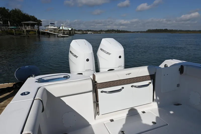 Slide: The Image of 2025 Tidewater 320 CC Adventure boat with dual Mercury engines on a calm waterway. - 18