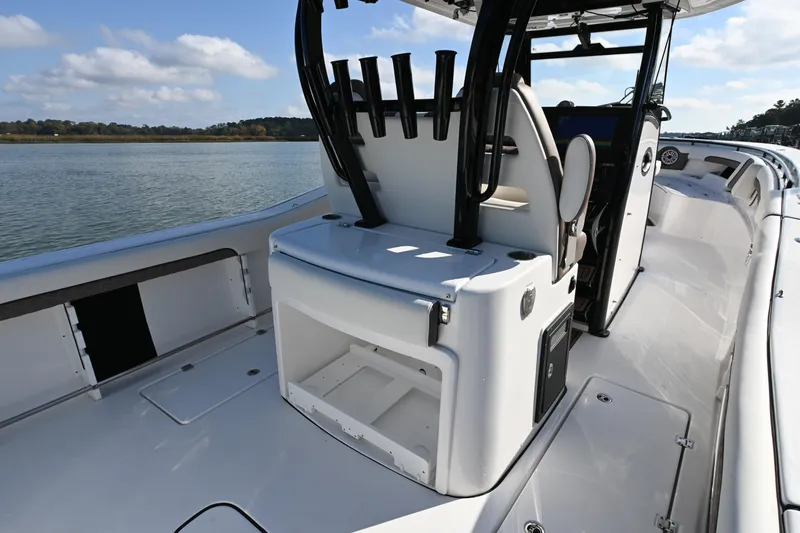 Slide: The Image of 2025 Tidewater 320 CC Adventure boat interior with seating and rod holders on a sunny day. - 20