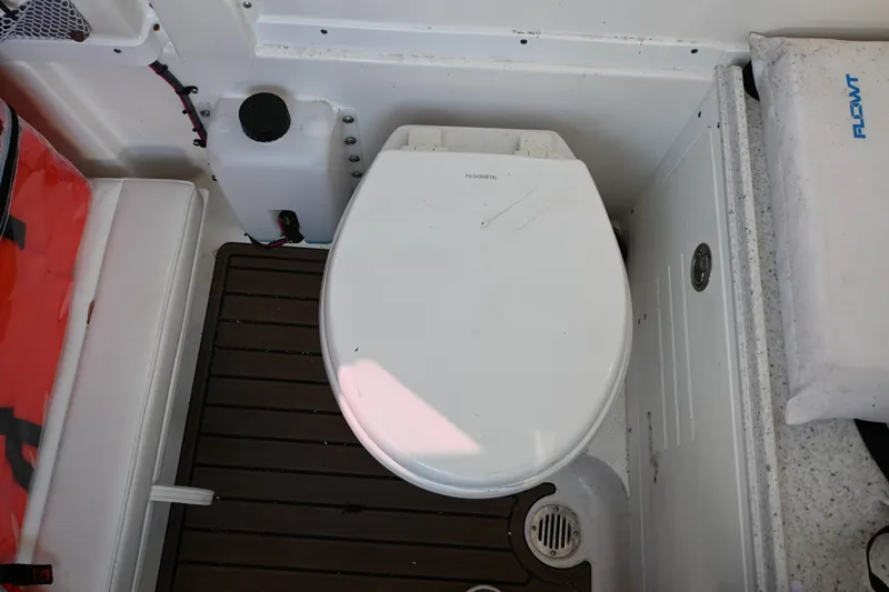 Slide: The Image of 2025 Tidewater 320 CC Adventure boat toilet area with wooden flooring. - 22