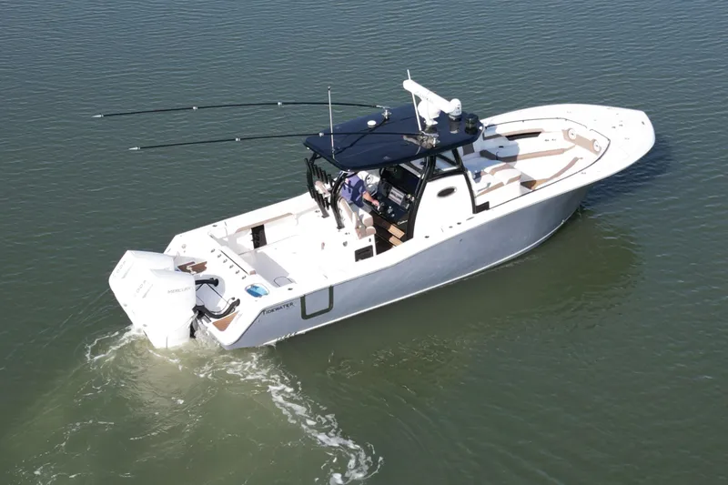 Slide: The Image of 2025 Tidewater 320 CC Adventure boat cruising on calm water. - 5