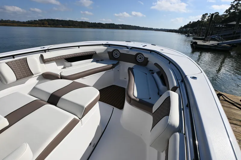 Slide: The Image of 2025 Tidewater 320 CC Adventure boat interior with luxurious seating on a serene lake. - 9