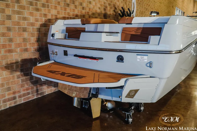 Slide: The Image of 2026 Axis T250 boat at Lake Norman Marina, showcasing rear deck and seating. - 7