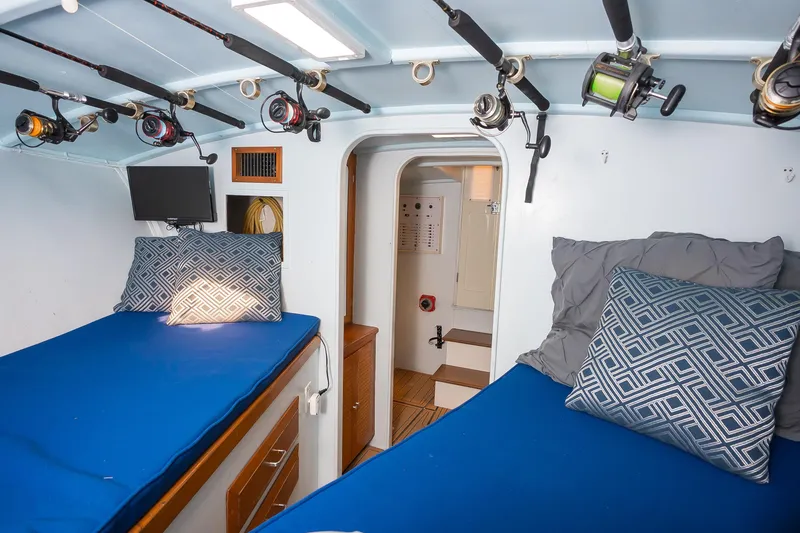 Slide: The Image of Interior of 1987 Custom Carolina Island Boatworks 34 Express with twin beds and fishing rods. - 24