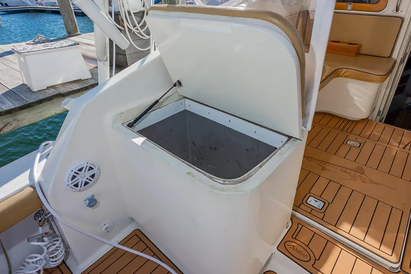 Slide: The Image of Open storage compartment on 1987 Custom Carolina Island Boatworks 34 Express, docked by the water. - 12