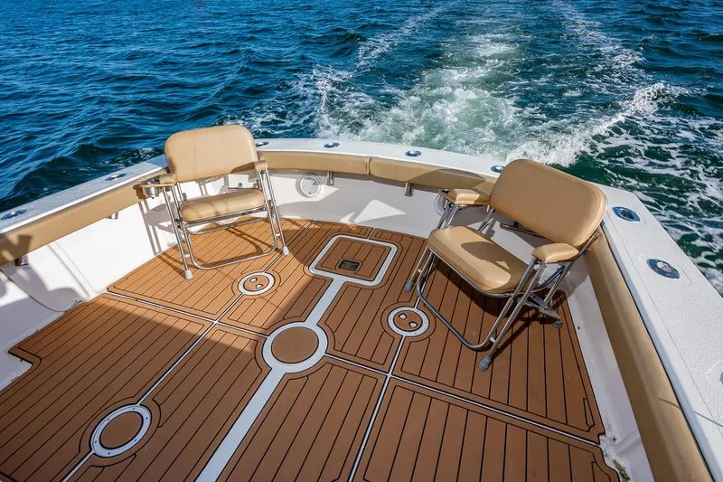 Slide: The Image of 1987 Custom Carolina Island Boatworks 34 Express, spacious deck with chairs, cruising on water. - 10