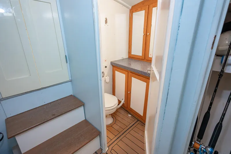 Slide: The Image of 1987 Custom Carolina Island Boatworks 34 Express bathroom with wooden cabinets and toilet. - 26