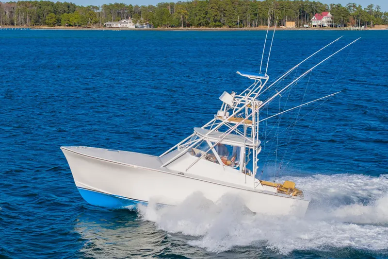 Slide: The Image of 1987 Custom Carolina Island Boatworks 34 Express cruising on blue water. - 6