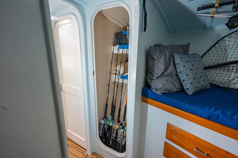 Slide: The Image of Interior of 1987 Custom Carolina Island Boatworks 34 Express with fishing rods and cozy bedding. - 27