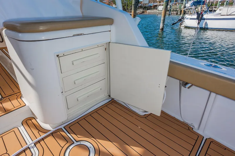 Slide: The Image of 1987 Custom Carolina Island Boatworks 34 Express interior with open storage compartment and teak flooring. - 11