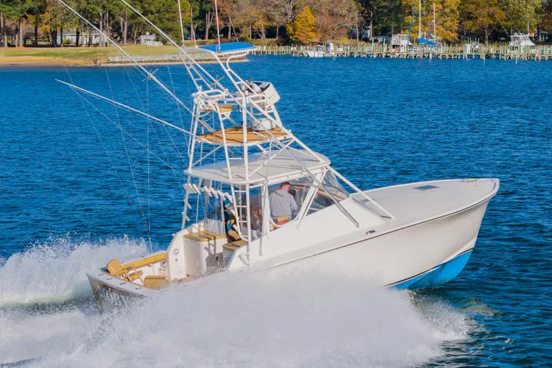 Slide: The Image of 1987 Custom Carolina Island Boatworks 34 Express cruising on a scenic lake. - 1