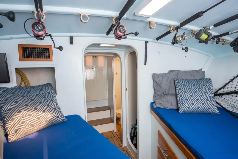 Slide: The Image of Interior of 1987 Custom Carolina Island Boatworks 34 Express with fishing rods and cozy bedding. - 25