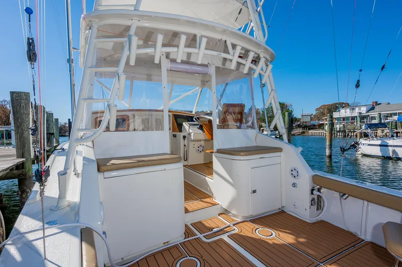 Slide: The Image of 1987 Custom Carolina Island Boatworks 34 Express, docked with clear skies and marina view. - 8