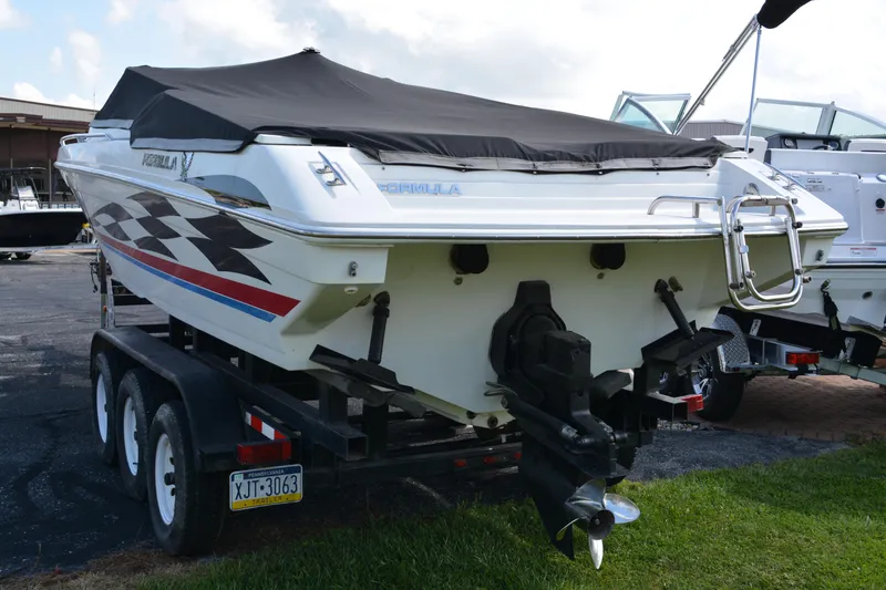 Slide: The Image of 2000 Formula 271 FASTech boat on trailer, covered, with checkered flag design. - 4