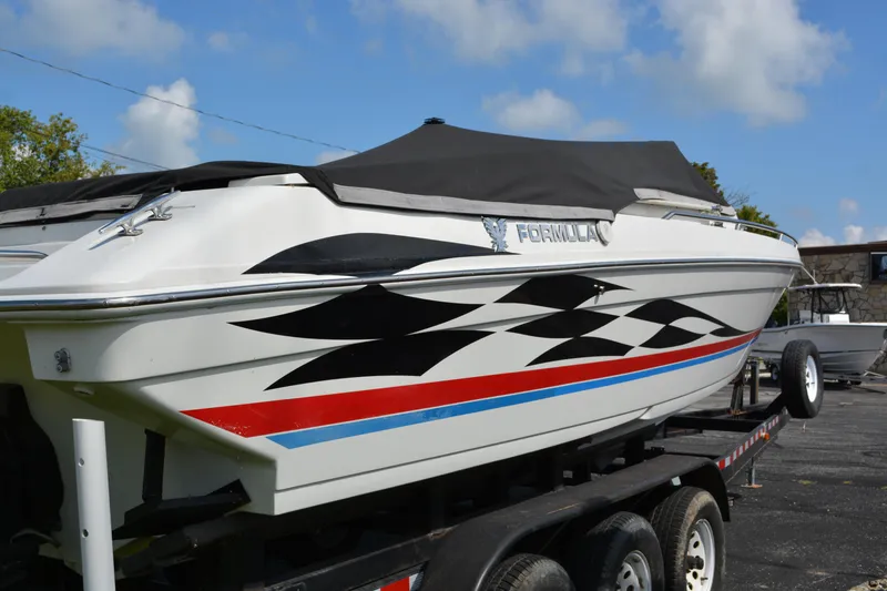 Slide: The Image of 2000 Formula 271 FASTech boat with black, red, and blue graphics on a trailer. - 6