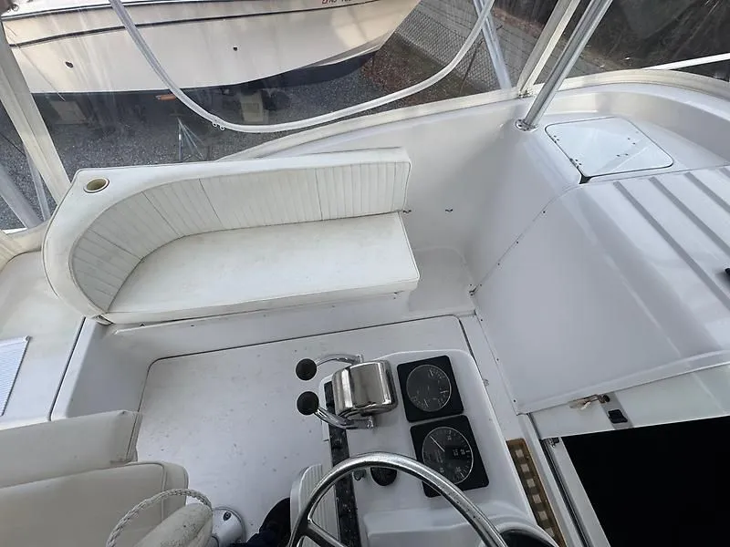 Slide: The Image of 1998 Luhrs 32 Express boat cockpit with white seating and control panel. - 10