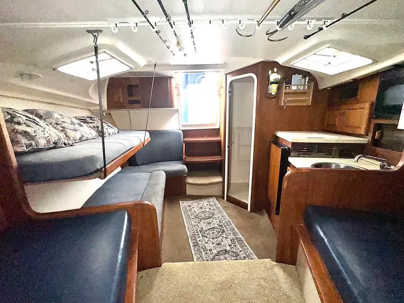 Slide: The Image of 1998 Luhrs 32 Express cabin interior with cozy seating, bunks, and kitchenette. - 3