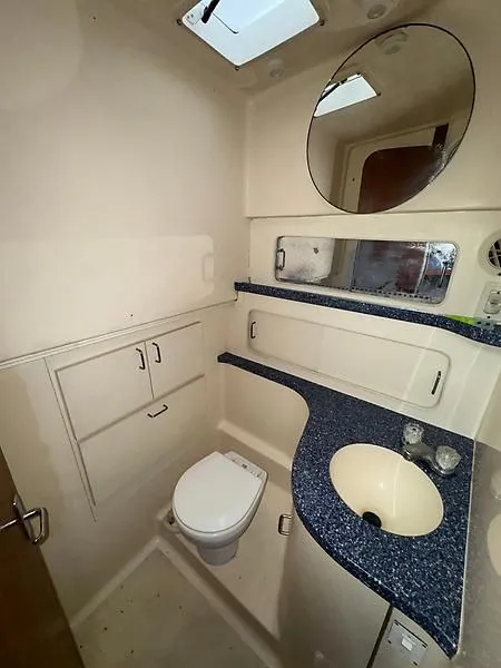 Slide: The Image of 1998 Luhrs 32 Express boat bathroom with blue countertop, mirror, and white fixtures. - 6