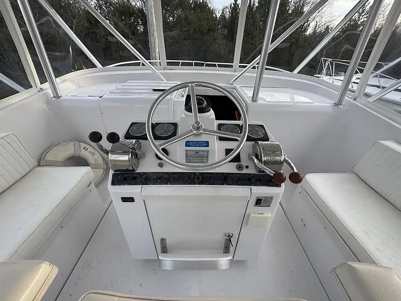 Slide: The Image of 1998 Luhrs 32 Express boat helm with steering wheel and controls. - 8