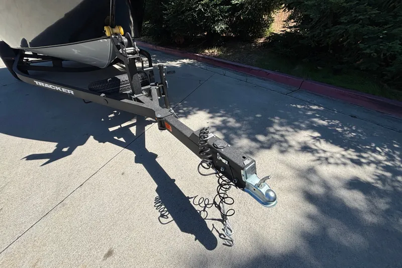 Slide: The Image of Trailer hitch of 2026 Tracker Pro Guide V-175 WT boat on pavement. - 19