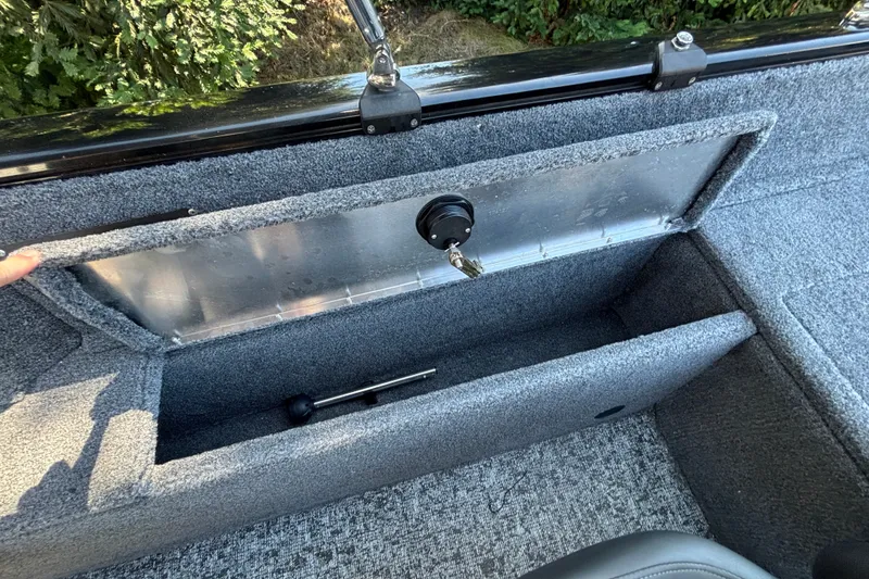 Slide: The Image of Storage compartment in 2026 Tracker Pro Guide V-175 WT boat, featuring carpeted interior and secure latch. - 27