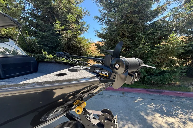 Slide: The Image of 2026 Tracker Pro Guide V-175 WT boat with Minn Kota PowerDrive motor in a wooded area. - 34