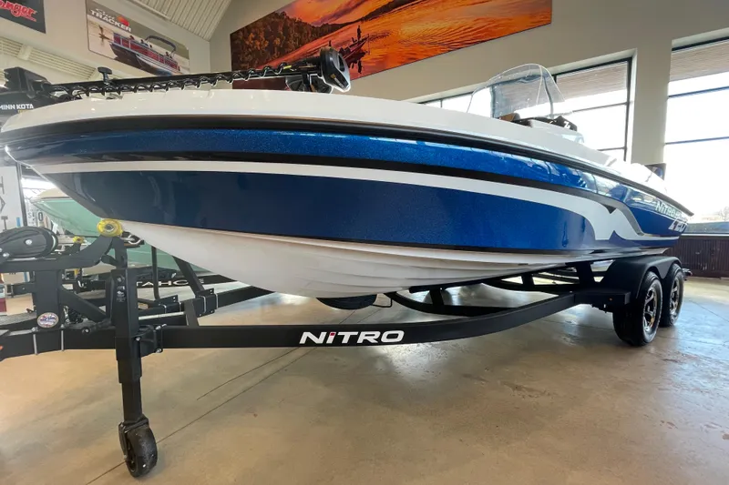 The Image of 2026 Nitro ZV20 Sport boat in showroom, blue and white design, on trailer. - 0