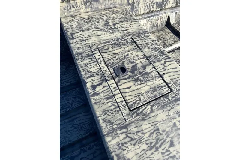 Slide: The Image of 2026 Tracker Grizzly 15 Jon boat with camouflage pattern and storage compartment. - 3