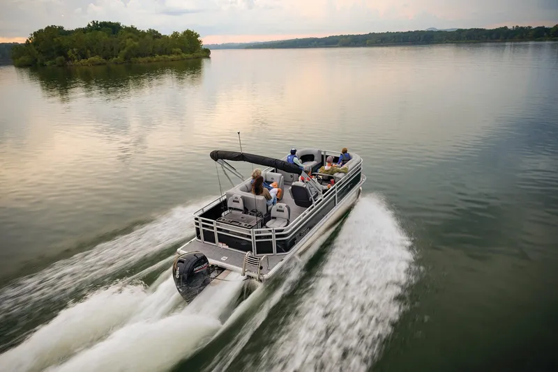 The Image of 2026 Sun Tracker SportFish 22 DLX pontoon boat on trailer, parked outdoors. - 1