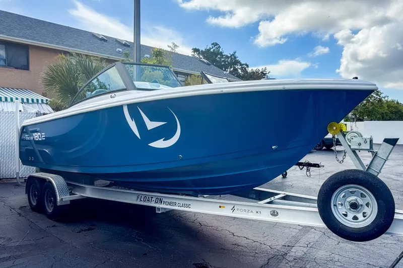 The Image of 2024 Aquasport AS DC 22 boat on trailer, blue hull, parked outdoors. - 0