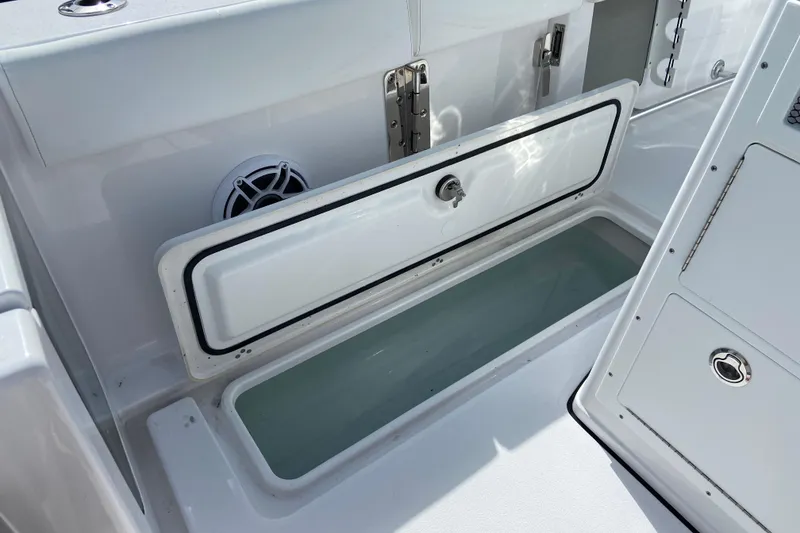 Slide: The Image of 2026 Sportsman Open 262 Center Console boat storage compartment with open hatch. - 10