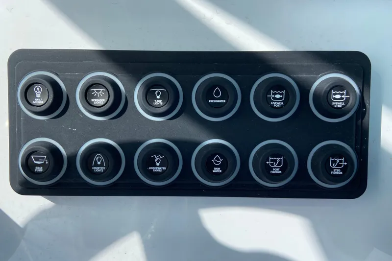 Slide: The Image of Control panel of a 2026 Sportsman Open 262 Center Console boat with labeled buttons. - 31