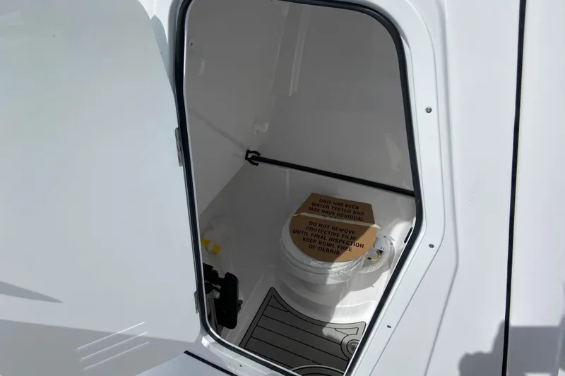 Slide: The Image of 2026 Sportsman Open 262 Center Console boat interior with a compact marine toilet. - 50