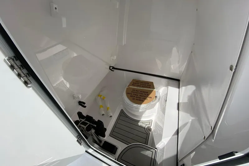 Slide: The Image of Interior of 2026 Sportsman Open 262 Center Console boat, featuring a compact restroom. - 51