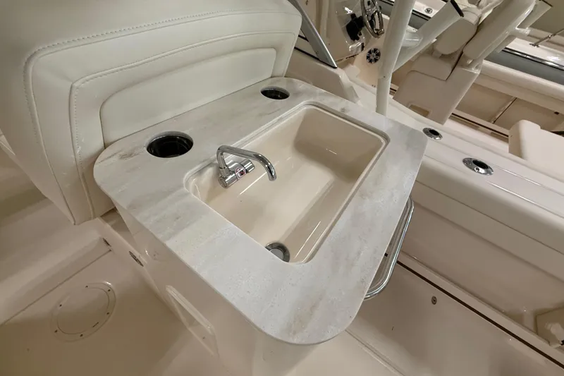 Slide: The Image of 2026 Grady-White Freedom 255 boat interior with sink and cup holders. - 11