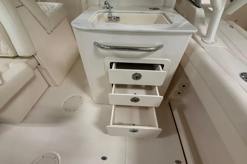 Slide: The Image of Interior of 2026 Grady-White Freedom 255 boat with sink and open storage drawers. - 12