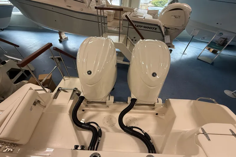 Slide: The Image of 2026 Grady-White Freedom 255 boat with dual outboard engines in showroom. - 15