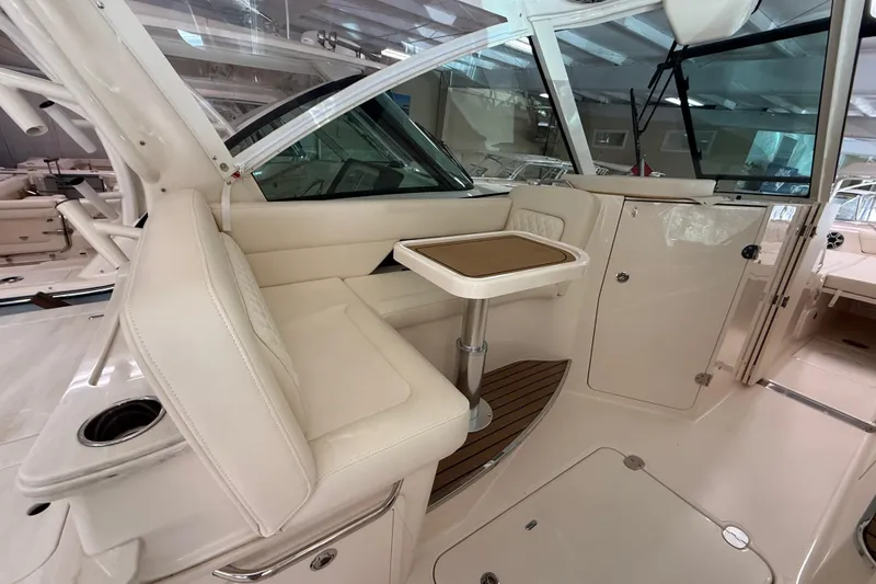 Slide: The Image of 2026 Grady-White Freedom 345 boat interior with beige seating and compact table. - 16