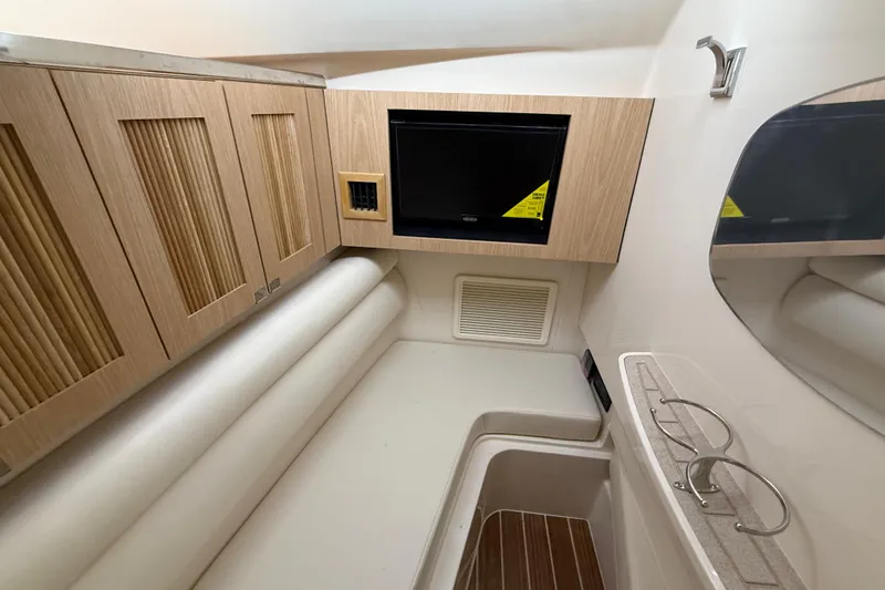 Slide: The Image of 2026 Grady-White Freedom 345 cabin interior with wood cabinetry and seating area. - 19