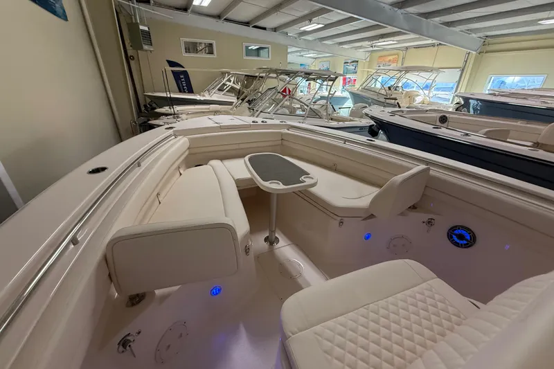 Slide: The Image of 2026 Grady-White Canyon 306 boat interior with seating and table in showroom. - 11