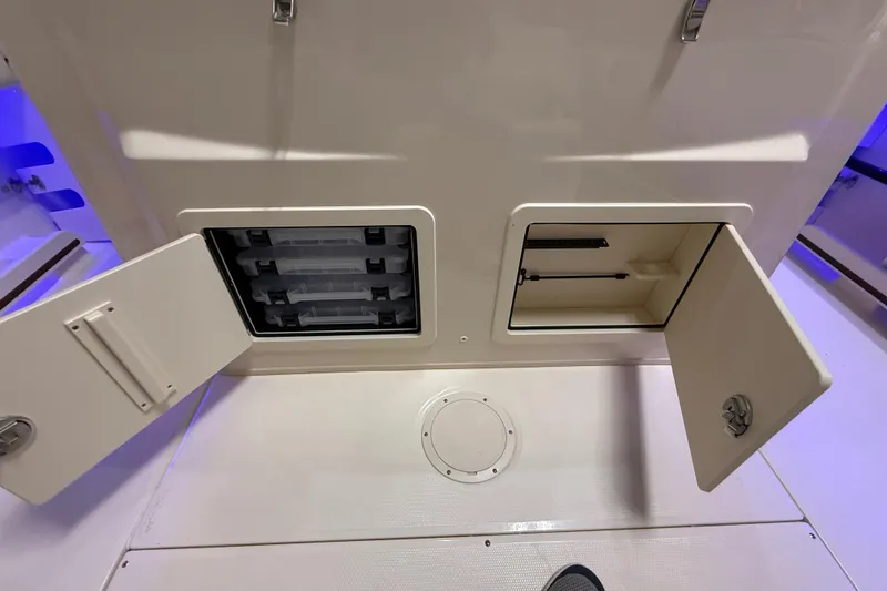 Slide: The Image of 2026 Grady-White Canyon 306 storage compartments with open doors, showcasing interior space. - 20