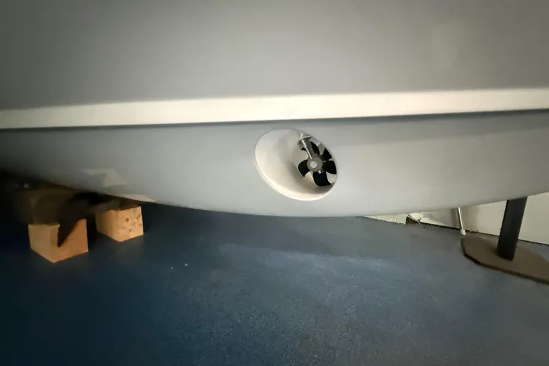 Slide: The Image of 2026 Grady-White Canyon 306 boat hull with bow thruster in a garage. - 26